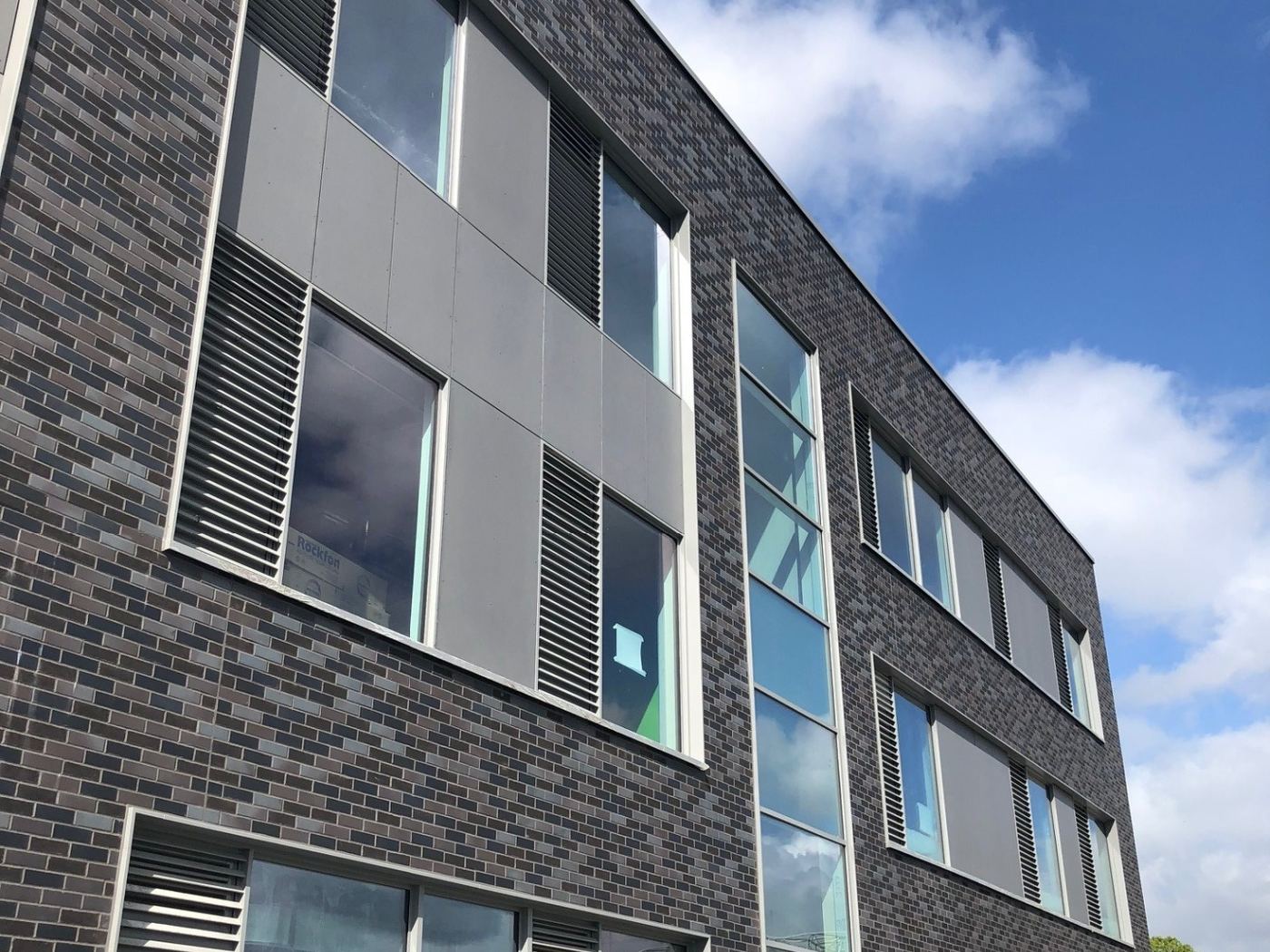 Dark brick-slip and grey panel façade at the Richmond Education and Enterprise Campus