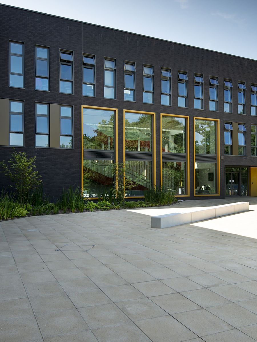 Dark brick-slip façade with gold-framed glazing at the Kennedy Building, University of Kent